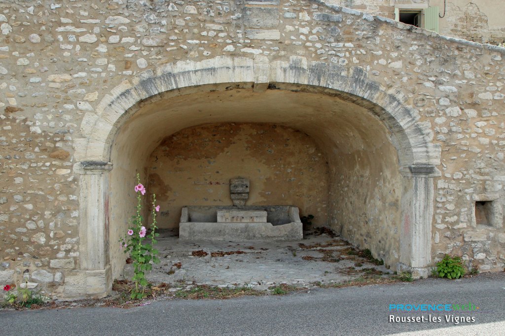 Fontaine sous un arc voûté.