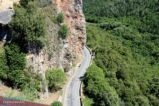 Chateaudouble, road with a cyclist down the gorges